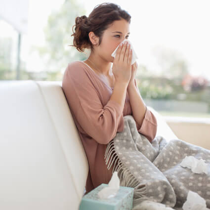 Woman sitting on couch with alliergies