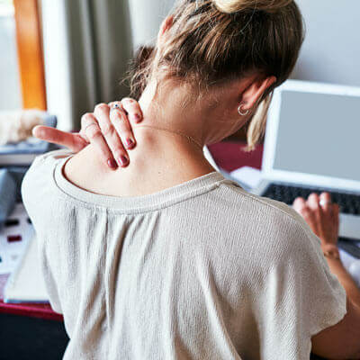 woman sitting at desk with neck pain