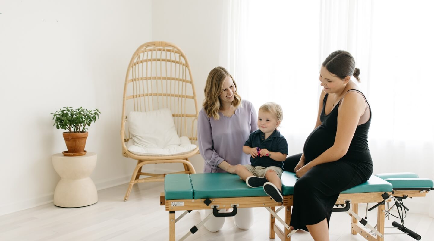 Chiropractor with mother and child patient