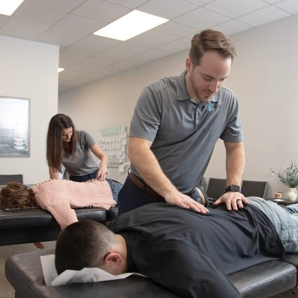 our doctors adjusting patients on tables