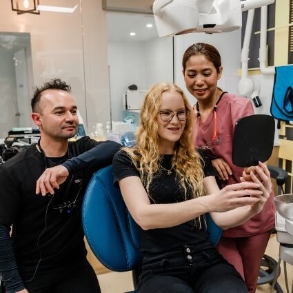 smiling Dentist in Hervey Bay patient looking in handmirror
