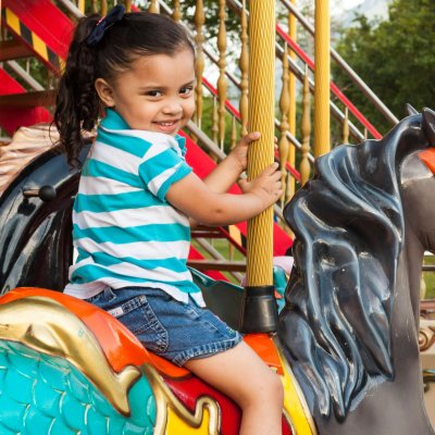 Joyful child enjoying a carousel ride in a vibrant amusement park setting.