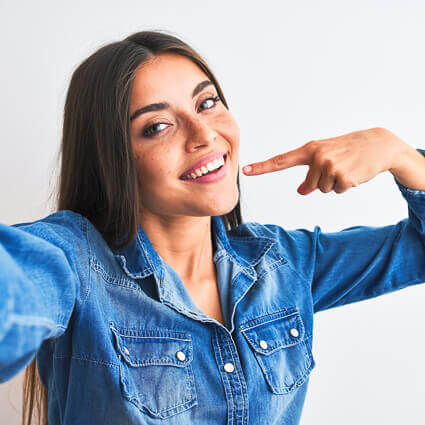 selfie of woman pointing to her teeth