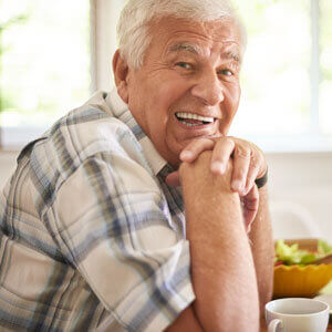 old-man-smiling-at-table-sq-300