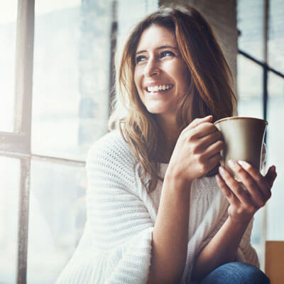 Woman drinking coffee while looking out window