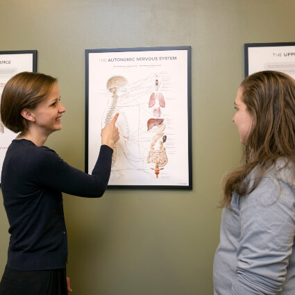 Dr. Annamarie pointing at spine model