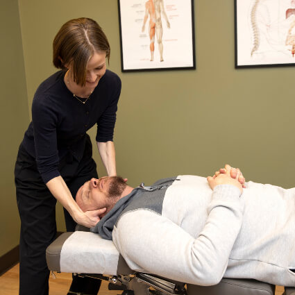 Dr. Annamarie adjusting man's neck