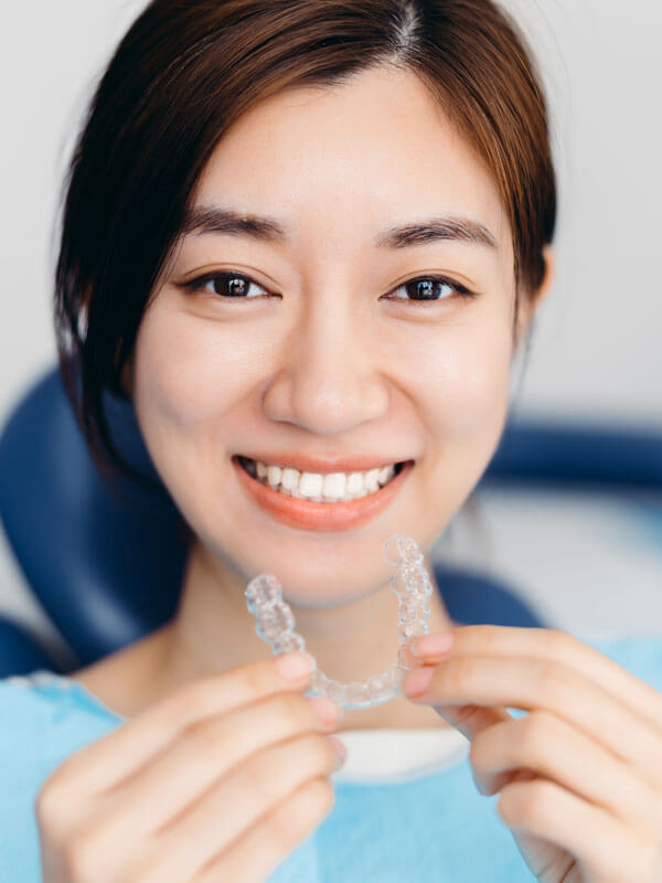 woman-holding-Invisalign-tray