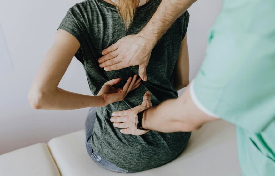 Chiropractor adjusting female patient's back