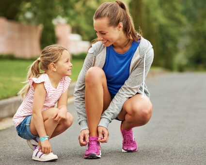 Mom and daughter tying their shoelaces