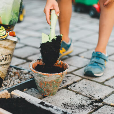 man putting soil in a garden pot