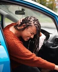 Woman exiting car experiencing neck pain