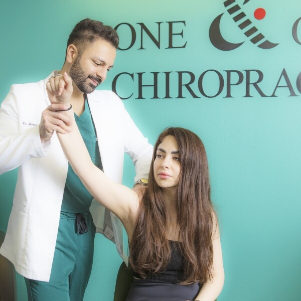 Chiropractor adjusting patient's shoulder