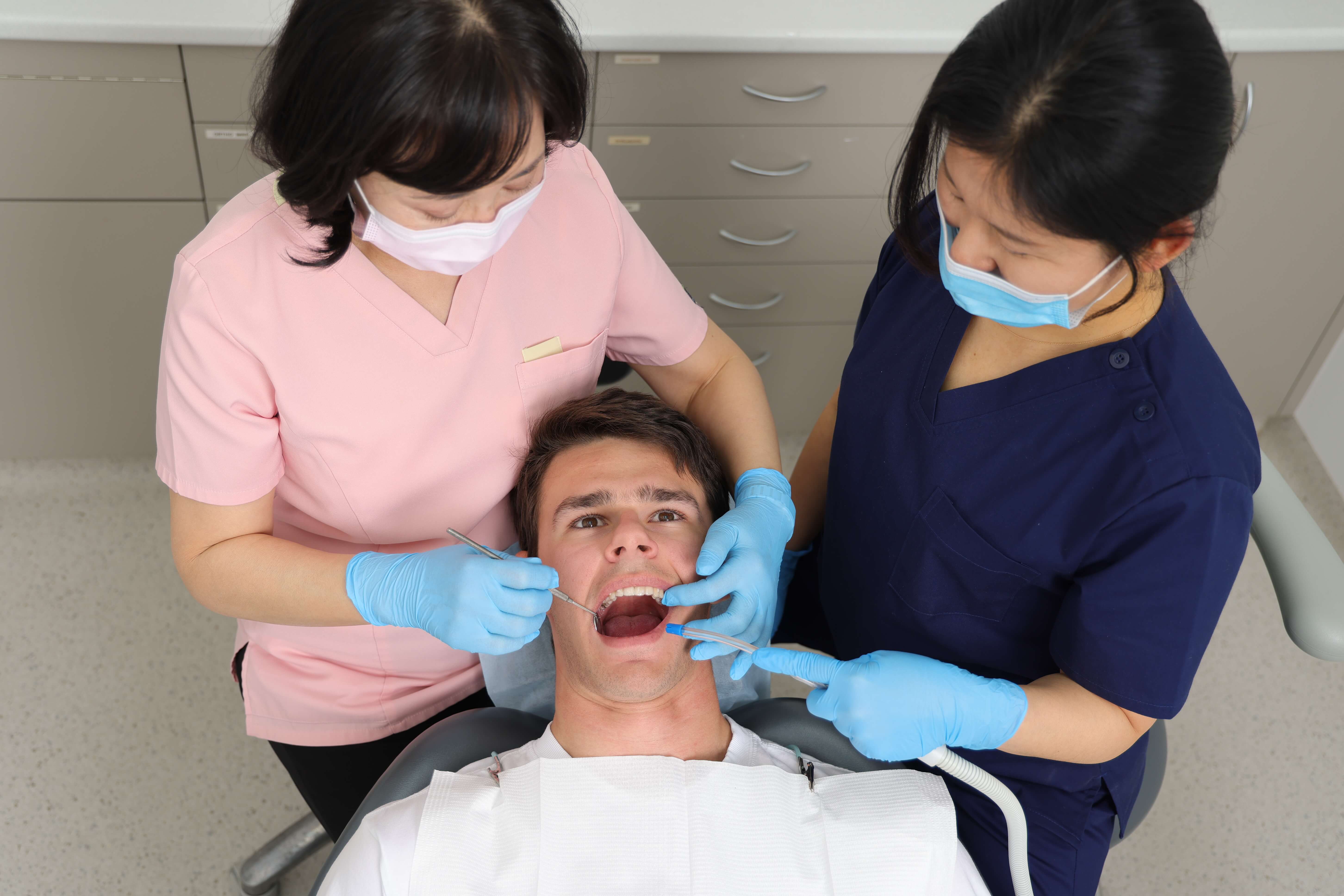 Dr cleaning patients teeth