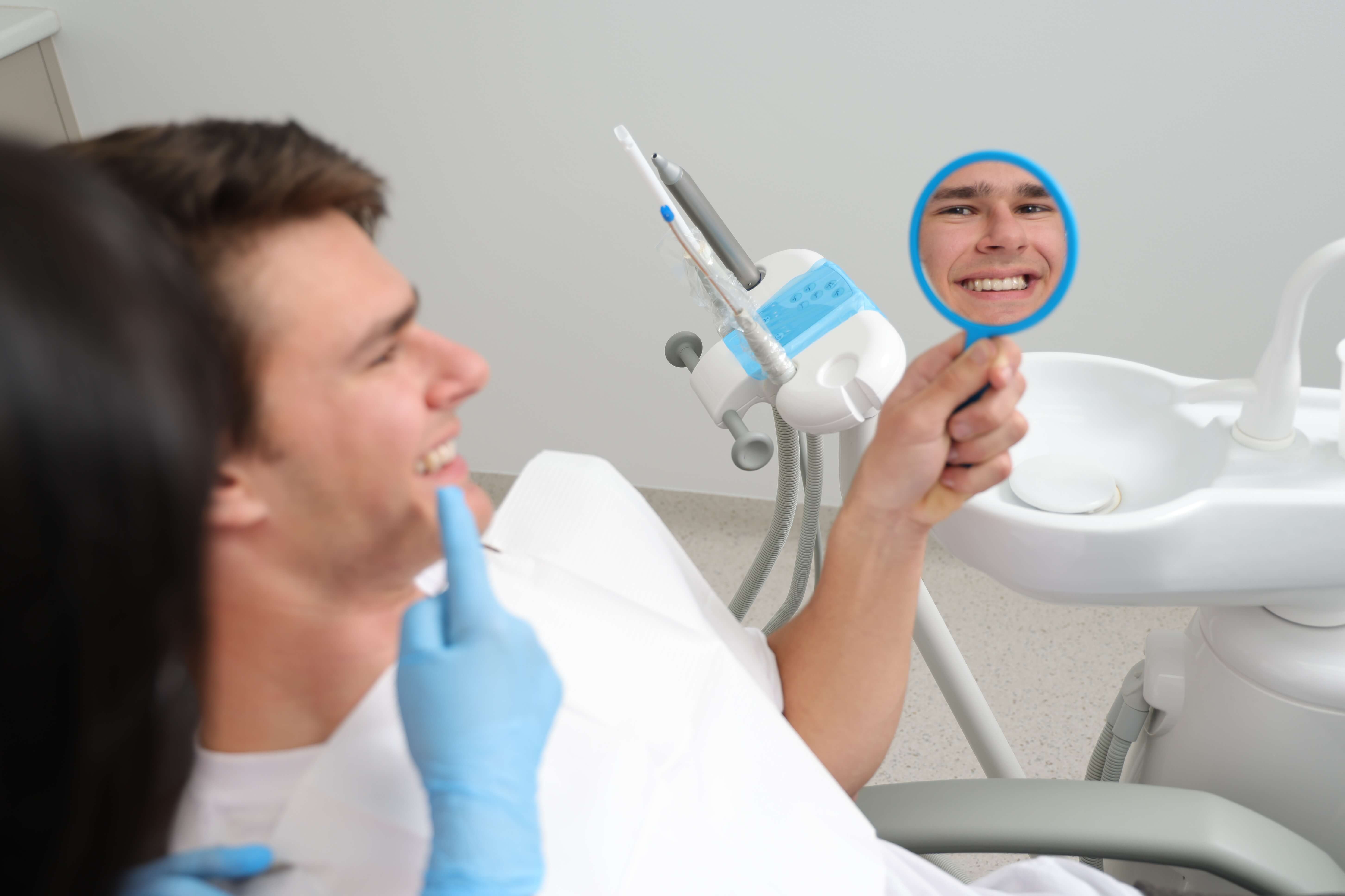 patient checking teeth in the mirror