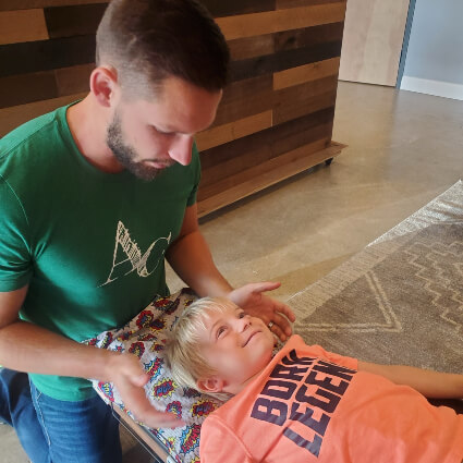 Dr. Ryan with young boy on adjustment table