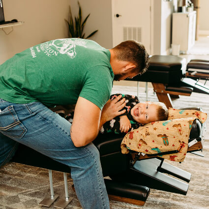 Dr. Ryan adjusting a smiling boy