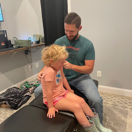 Dr. Ryan adjusting young girl