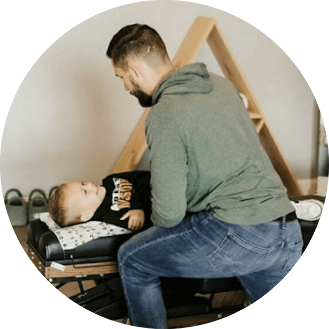 Chiropractor adjusting young patient