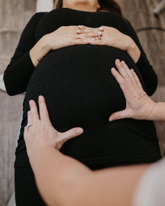 Dr. Leslie with hands on pregnant woman's stomach