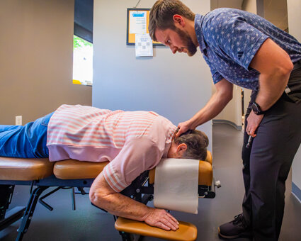 doctor adjusting patients neck on table
