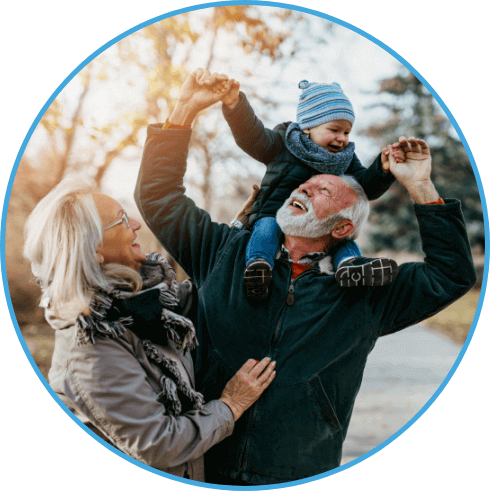 smiling grandparents walking outdoors with baby