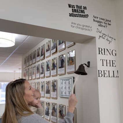 mom and baby ringing the bell at Clear Health and Wellness
