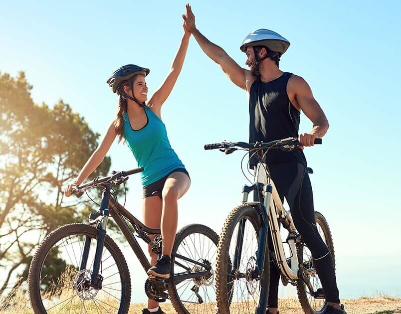 people on bicycles high-fiving