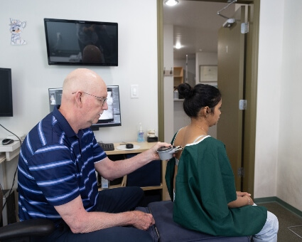 Dr. Prii using nervo scope test on patient