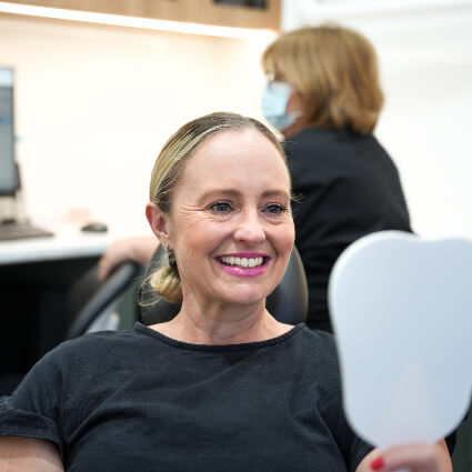 Patient smiling in mirror