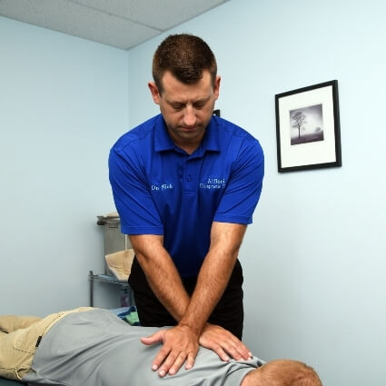 Portage chiropractor Dr Nick adjusting patients back 