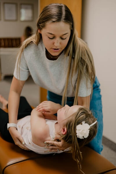 chiropractor adjusting child laying on table