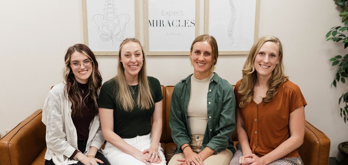 four team members sitting on couch