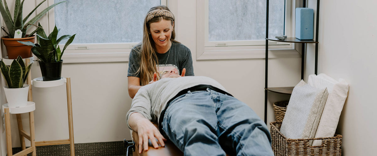 Dr. Stephanie adjusting male patient on table