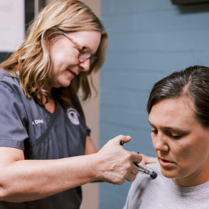 Grain Valley Chiropractor Dr. Catherine using Activator on shoulder