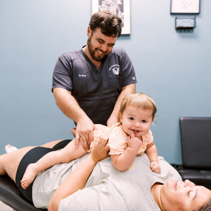 Chiropractor adjusting baby on mom