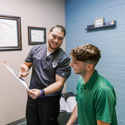 Chiropractor reviewing chart with patient