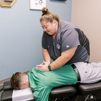 Chiropractor adjusting man's back