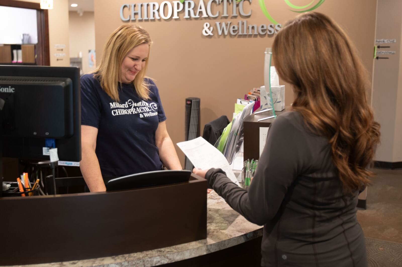 Millard Family Chiropractic & Wellness receptionist interacting with Omaha patient