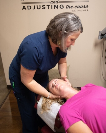 Omaha chiropractor Dr. Sheri Millard adjusting femal patient's neck