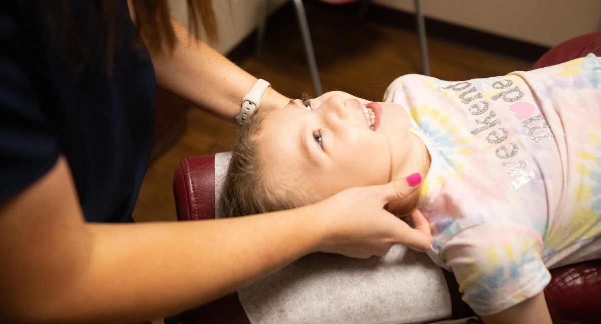 Omaha chiropractor adjusting pediatric patient's neck