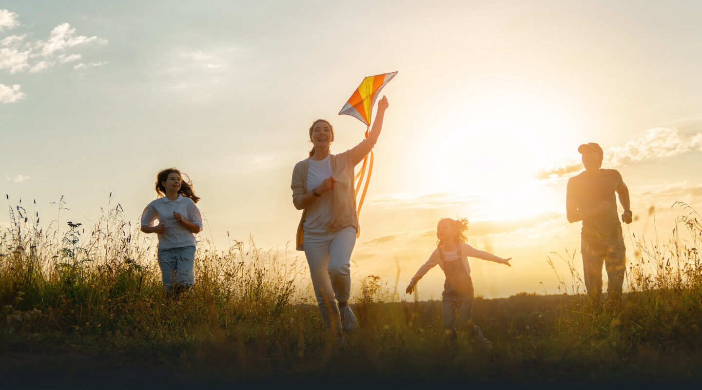 family of four playing kite