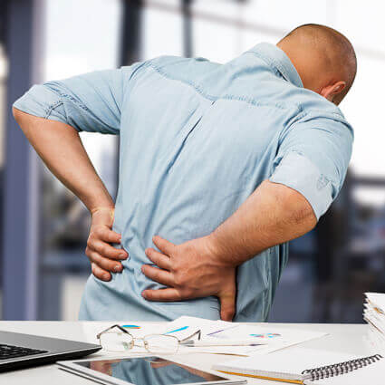 back of man sitting at desk with back pain