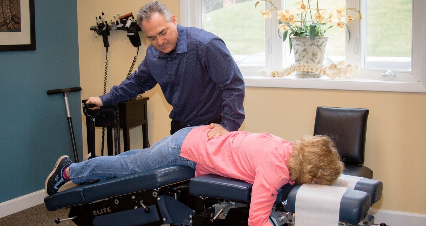 Palmyra chiropractor Dr. Carmelo Cartazzolo adjusting female patient