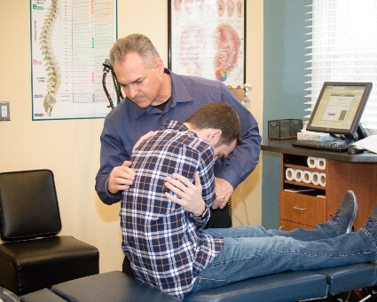 Palmyra chiropractor Dr. Carmelo Caratozzolo adjusting a patient