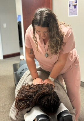 Chiropractor pressing on woman's back