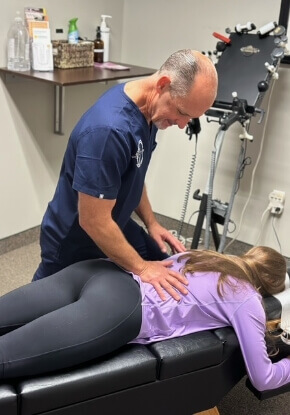 Dr. Frank adjusting woman's mid back