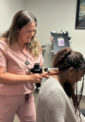 Dr. Haley using tool to adjust woman's neck