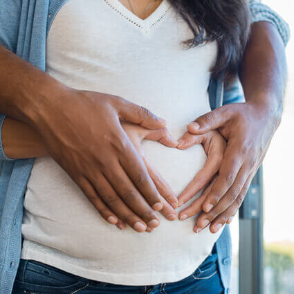 close-up-of-hands-forming-a-heart-on-pregnant-belly-sq