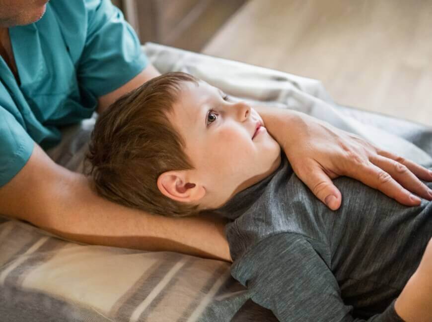 Hands around a toddler on adjusting table